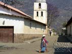 Indian woman carrying her purchases home with the Pojo church in the background, Cochabamba, Bolivia